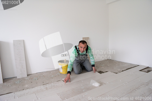 Image of worker installing the ceramic wood effect tiles on the floor