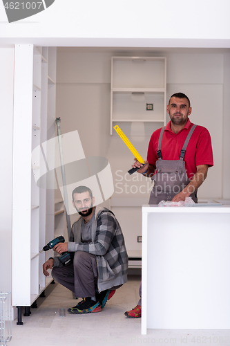 Image of young workers installing a new kitchen