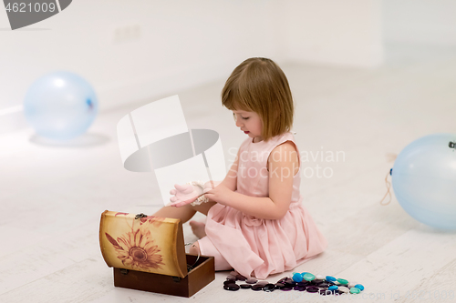 Image of little girl enjoying while playing with mother\'s jewelry