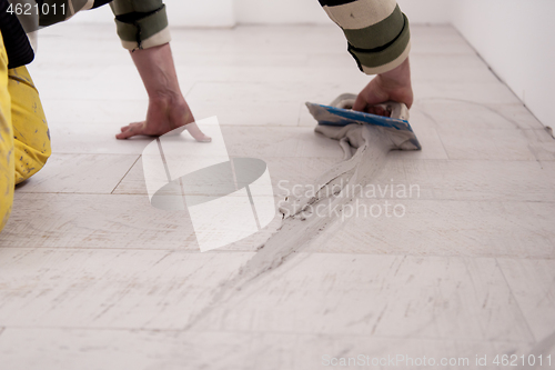 Image of Tilers filling the space between ceramic wood effect tiles