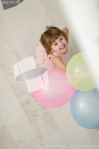 Image of cute little girl playing with balloons