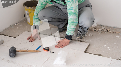 Image of worker installing the ceramic wood effect tiles on the floor