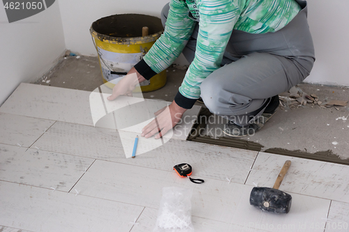 Image of worker installing the ceramic wood effect tiles on the floor