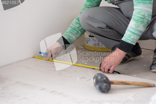 Image of worker installing the ceramic wood effect tiles on the floor