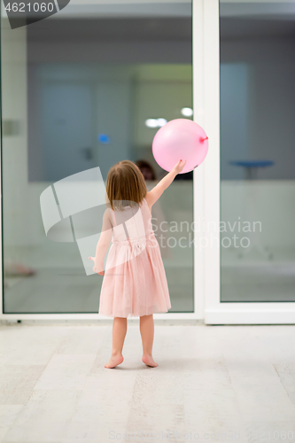 Image of cute little girl playing with balloons