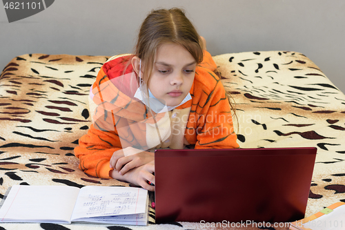 Image of A sick quarantined girl learns remotely using a laptop