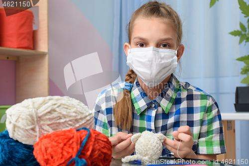 Image of A girl in quarantine self-isolation is engaged in knitting