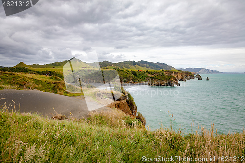 Image of sea shore rocks and mount Taranaki, New Zealand