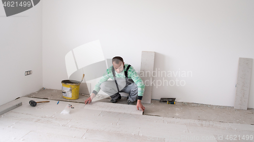 Image of worker installing the ceramic wood effect tiles on the floor