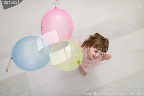 Image of cute little girl playing with balloons