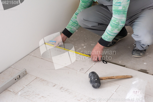 Image of worker installing the ceramic wood effect tiles on the floor