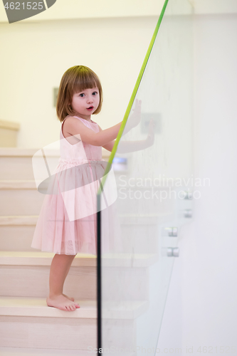 Image of little girl playing on stairs at home