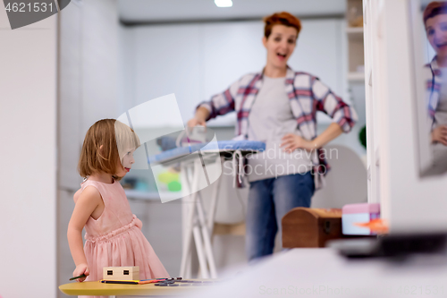 Image of mother and little daughter spending time together at home