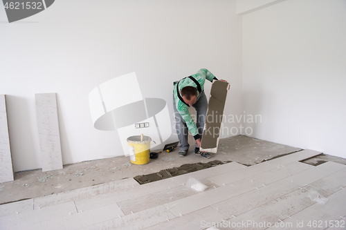 Image of worker installing the ceramic wood effect tiles on the floor