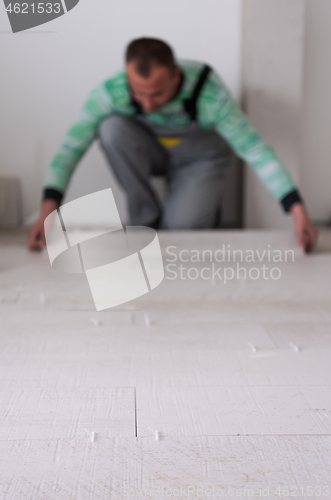 Image of worker installing the ceramic wood effect tiles on the floor