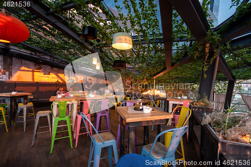 Image of blurred people in cafe decorate with hanging plant