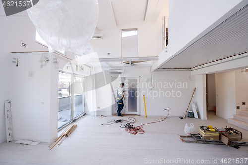 Image of carpenters installing glass door with a wooden frame