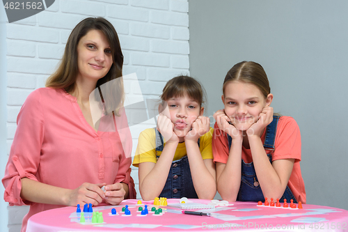 Image of Young family plays board games and looked into the frame