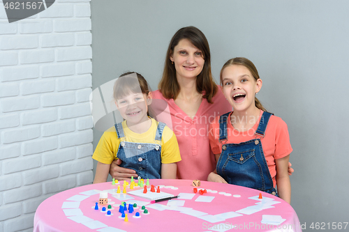 Image of Happy family having fun laughing while playing board games at a table