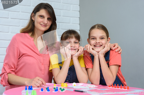 Image of Portrait of a happy family playing board games at a table