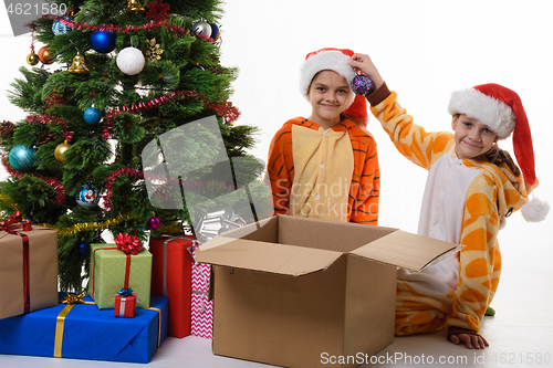 Image of Children show what a beautiful ball they found in a box with New Year\'s toys.