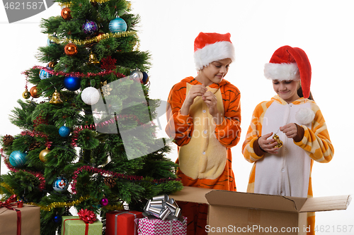 Image of Girls examine New Year\'s toys decorating the Christmas tree