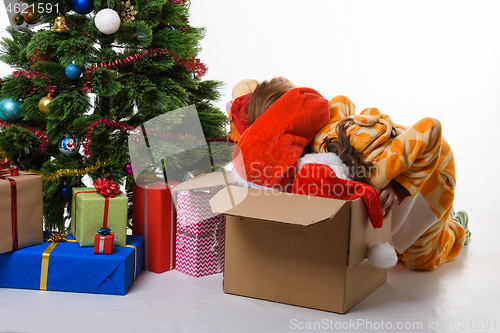 Image of Two girls crawled headlong into a box with New Year\'s toys