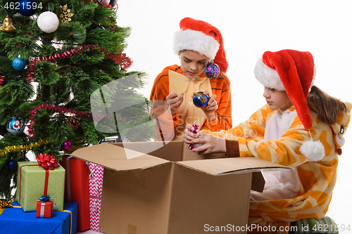 Image of Children make out a box with New Year\'s toys