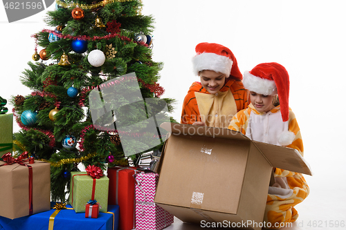 Image of Two girls look in a box with New Year\'s toys