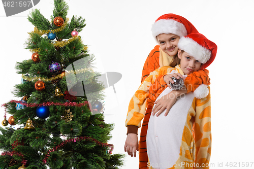 Image of Girl hugs another girl near the New Year tree