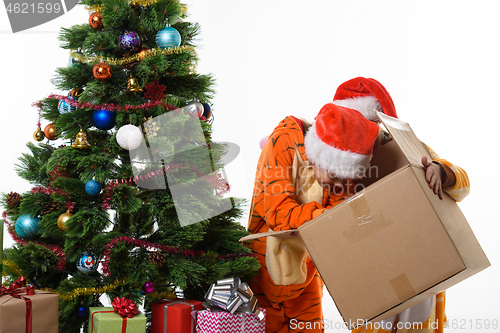 Image of One girl holding a box, another girl looking for Christmas toys in a box