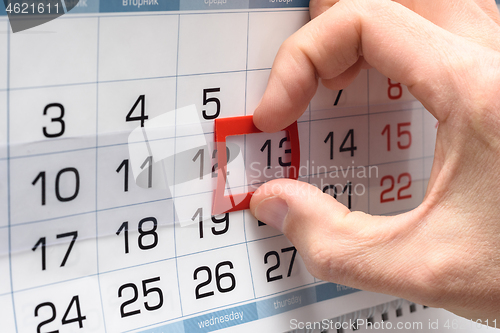 Image of The hand on the calendar moves the pointer from the twelfth to the thirteenth