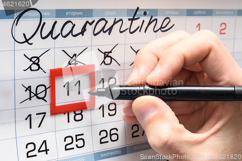 Image of A hand crosses out the next day on the calendar during the quarantine period
