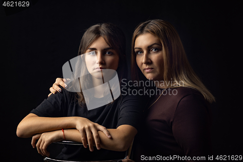 Image of Black and white portrait of mother and daughter on a black background