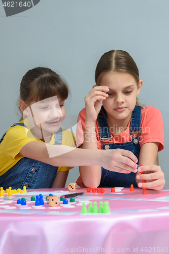 Image of Two girls enthusiastically play a board game