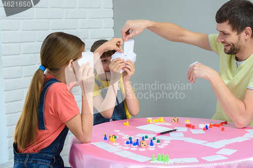 Image of Dad draws the desired card in a board game with daughters