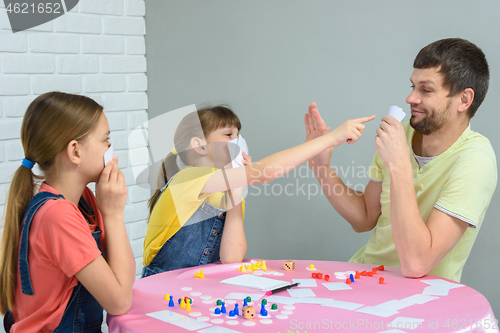Image of Daughter points to dad\'s cards in a board game