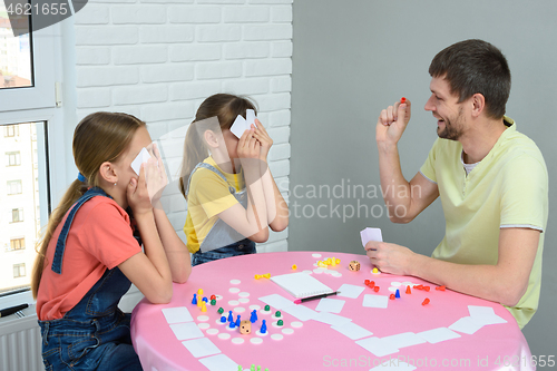 Image of Dad and daughters play board games at home