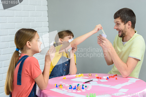 Image of Children draw dad\'s card in a fun board game