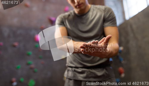 Image of male climber drying hands at indoor climbing gym