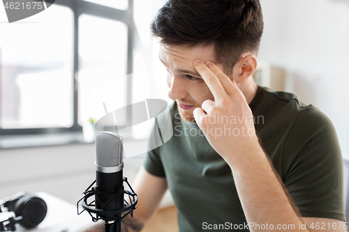 Image of male audio blogger with microphone broadcasting