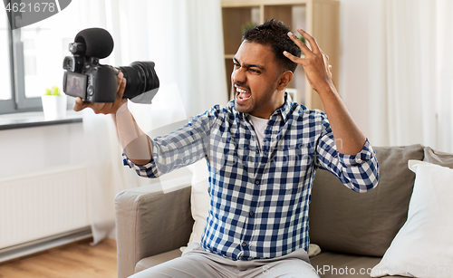 Image of male video blogger with camera blogging at home