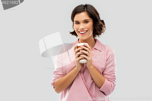 Image of woman drinking takeaway coffee in paper cup