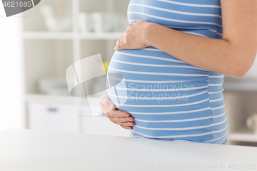 Image of pregnant woman with big tummy at home