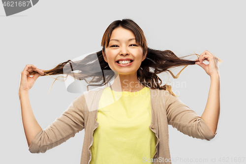 Image of happy asian woman with waving hair