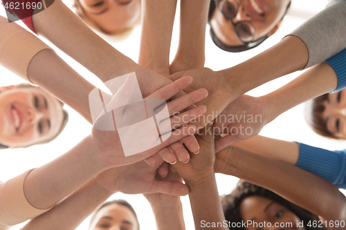 Image of close up of international women stacking hands