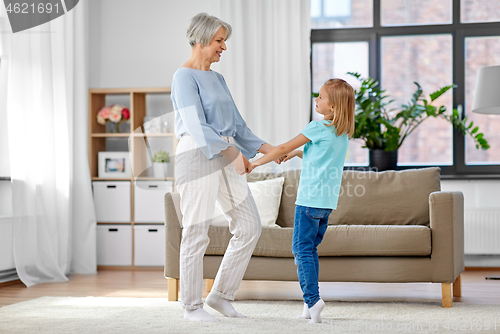 Image of grandmother and granddaughter having fun at home