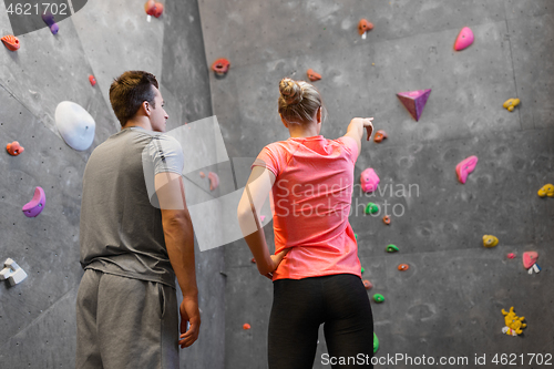 Image of man and woman exercising at indoor climbing gym