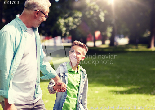 Image of grandfather and grandson walking at summer park