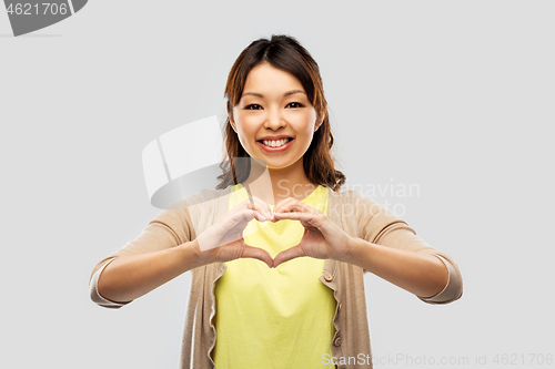 Image of asian woman making hand heart gesture